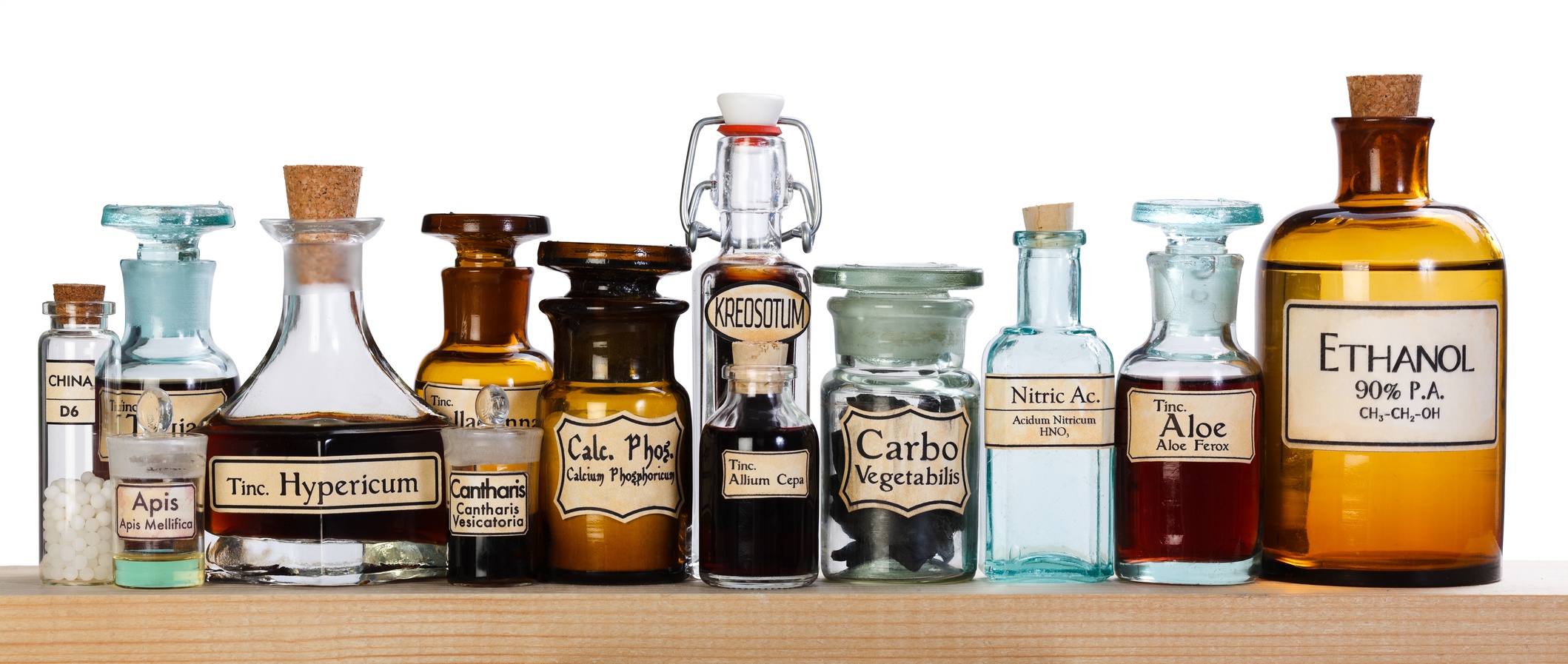 Various pharmacy bottles of homeopathic medicine on wooden board